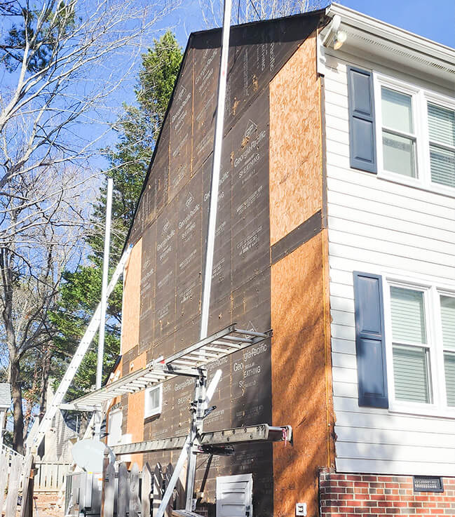 Workers installing new siding on a home in Cary, NC