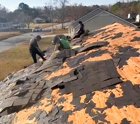 Skilled contractors removing old roof shingles from a house, Raleigh and surroundings areas