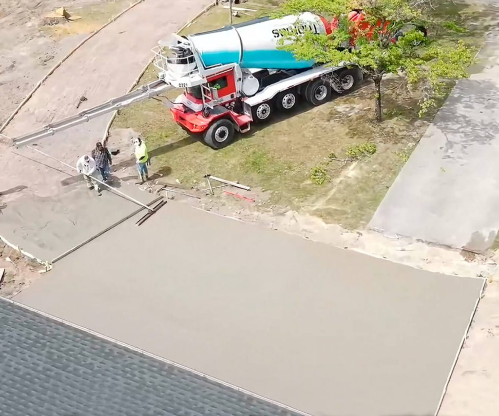 A newly installed concrete driveway with a smooth finish, showing clean lines and a well-constructed surface.