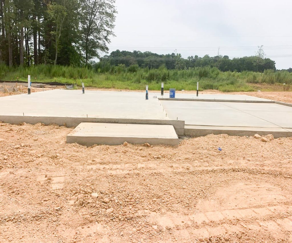 A freshly poured concrete driveway, showcasing a neat finish and robust construction, ready for use.