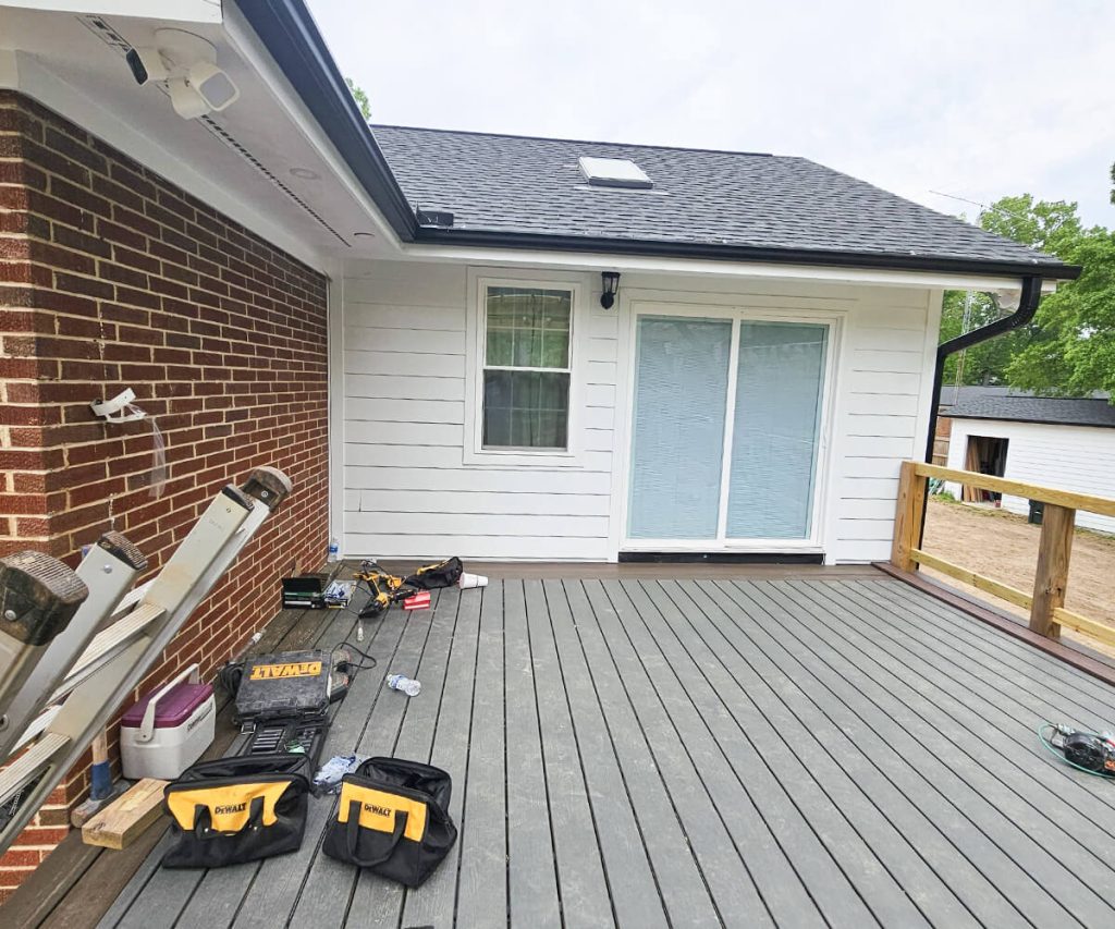 A home showcasing a newly installed deck and new gutters, highlighting both outdoor living space and effective water management.