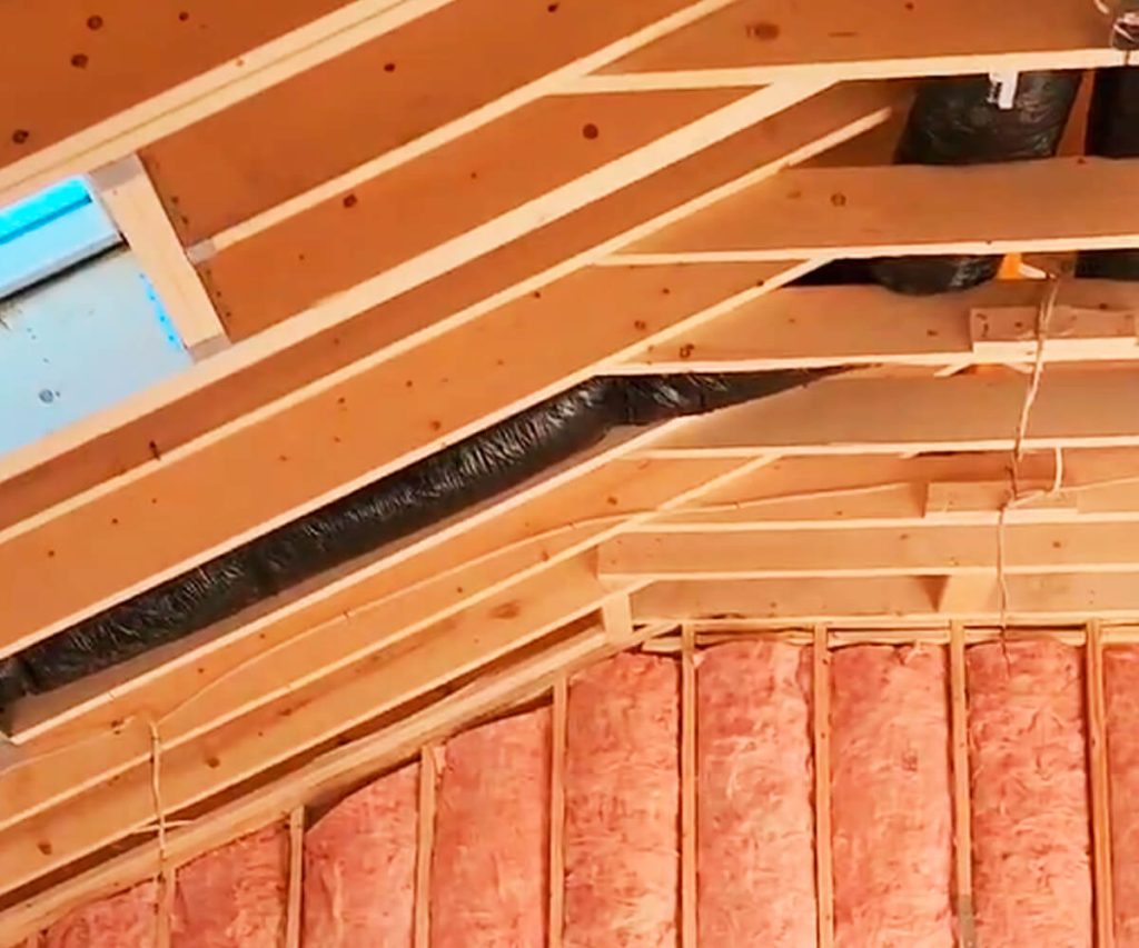 A general contractor managing the framing and insulation phases of a construction project, showcasing the structured framework and insulation materials being installed.