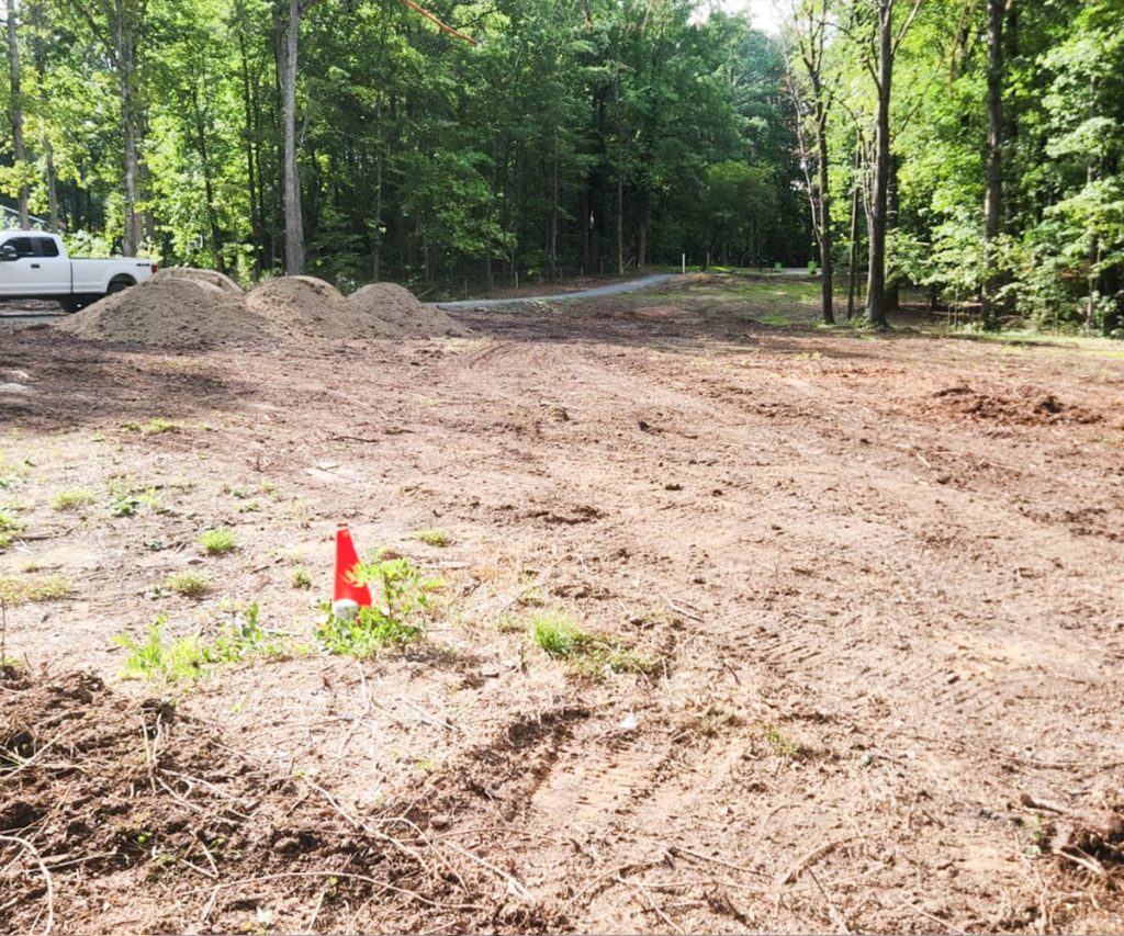 A site undergoing grading, showing a leveled and properly sloped area, prepared for landscaping or construction.