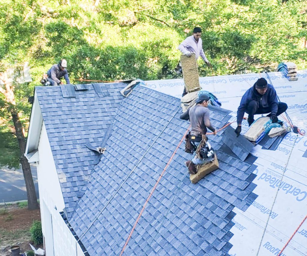 A new roof installation nearly complete, showing the final stages of roofing with most of the shingles or materials in place.