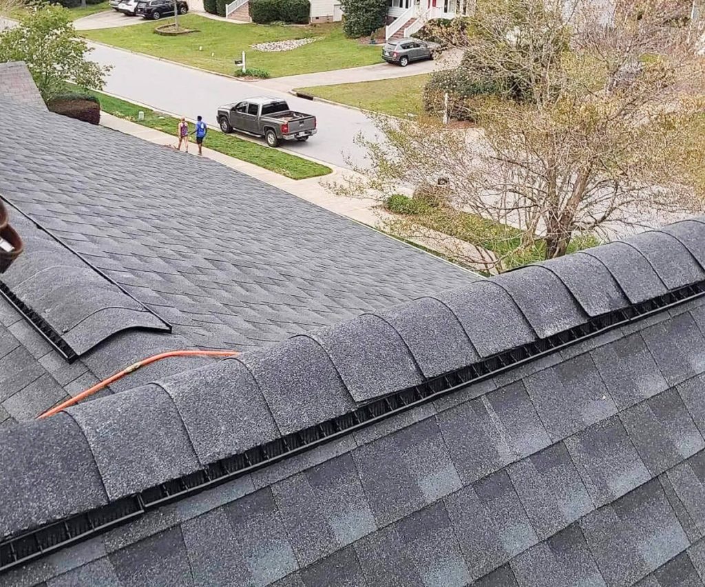 A new roof installation on a home with the surrounding neighborhood visible in the background, showcasing the updated roofing in the community context.